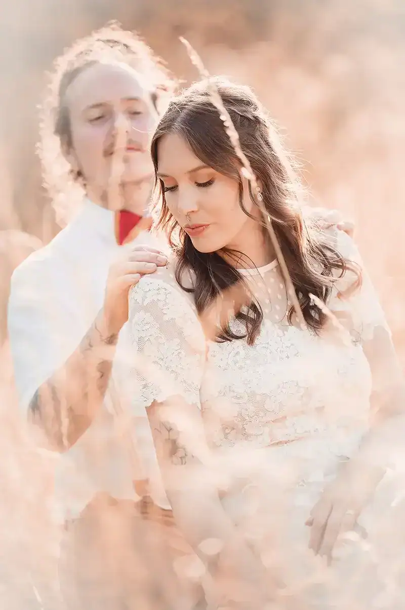 Groom holds the brides shoulder in hay field - Scott Gilbert Wedding Photography