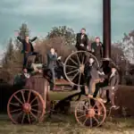 Groomsmen position themselves on an old steam engine at South Farm - Scott Gilbert Wedding Photography