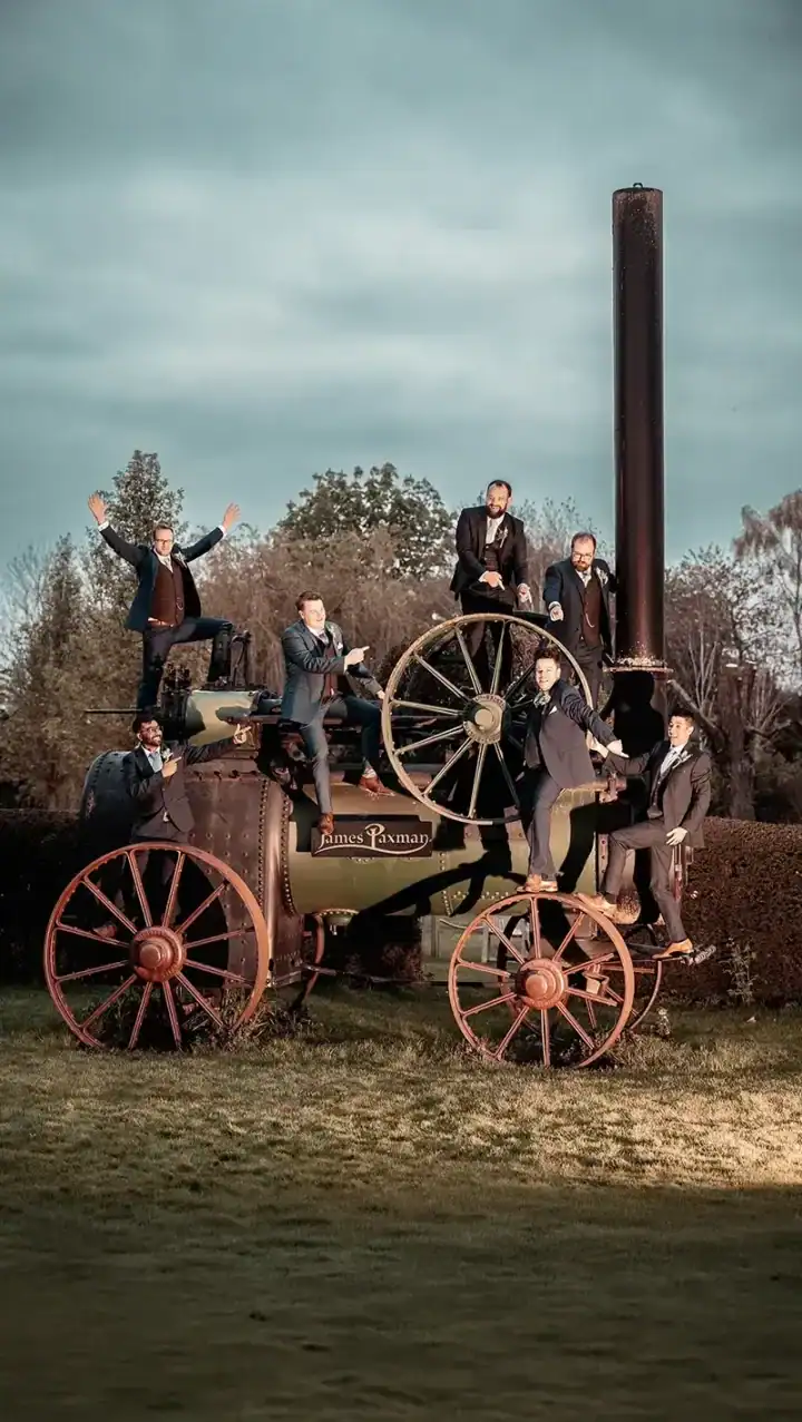 Groomsmen position themselves on an old steam engine at South Farm - Scott Gilbert Wedding Photography