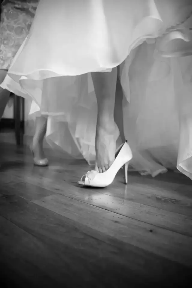 Lucy & Michael 1 Bride slips into her white shoes - Scott Gilbert Wedding Photography
