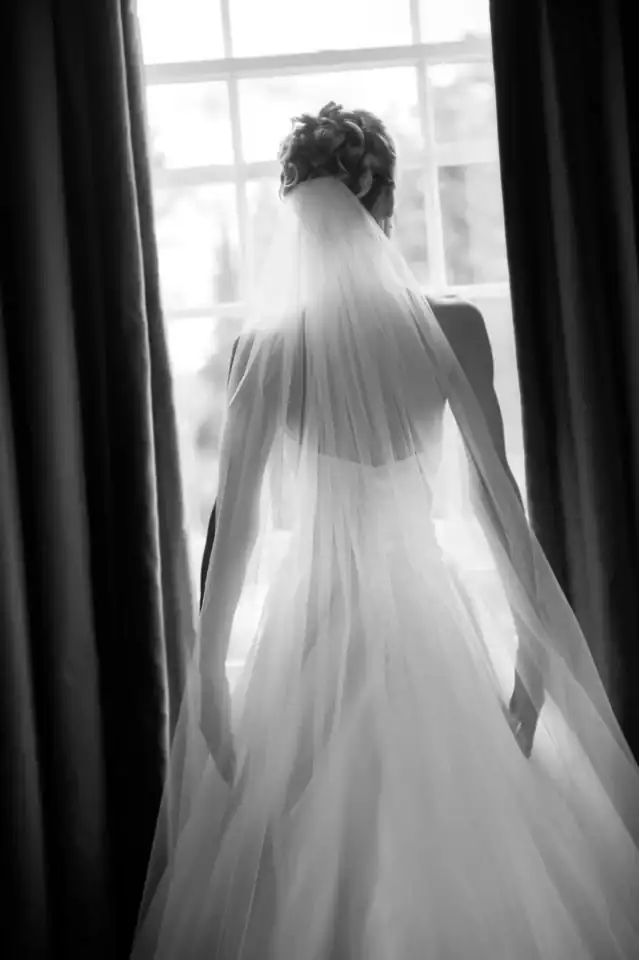 Lucy & Michael 14 Bride stares out of window wearing her white wedding dress - Scott Gilbert Wedding Photography