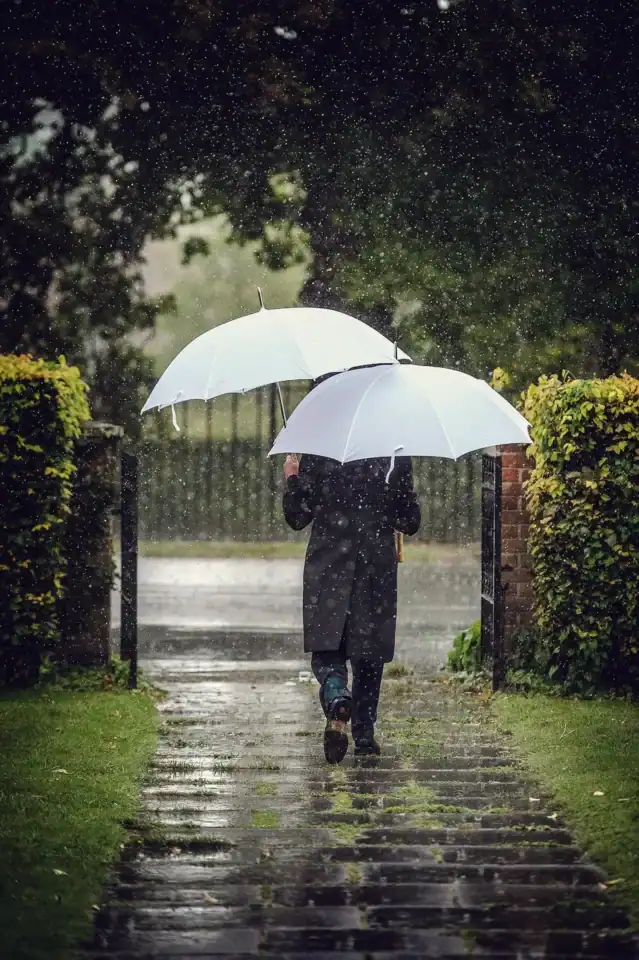 Groom avoids the rain with double umbrella - Scott Gilbert Wedding Photography