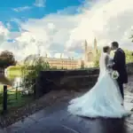 Happy couple kiss on bridge outside Kings College Cambridge - Scott Gilbert Wedding Photography