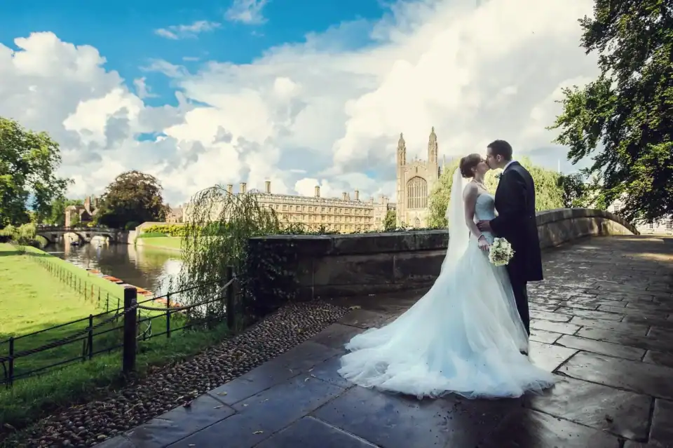 Happy couple kiss on bridge outside Kings College Cambridge - Scott Gilbert Wedding Photography
