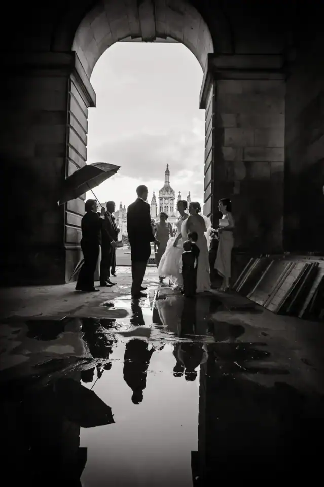 Wedding party avoid the rain at Cambridge University venue - Scott Gilbert Wedding Photography
