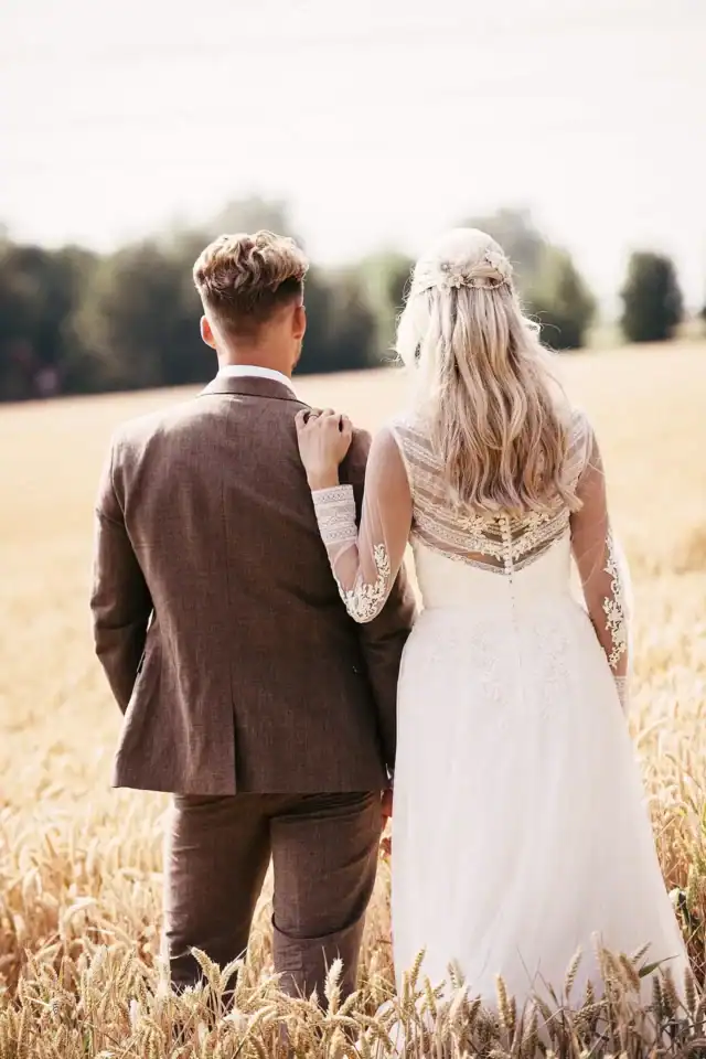 Bride and groom gaze into the distance from field - Scott Gilbert Wedding Photography