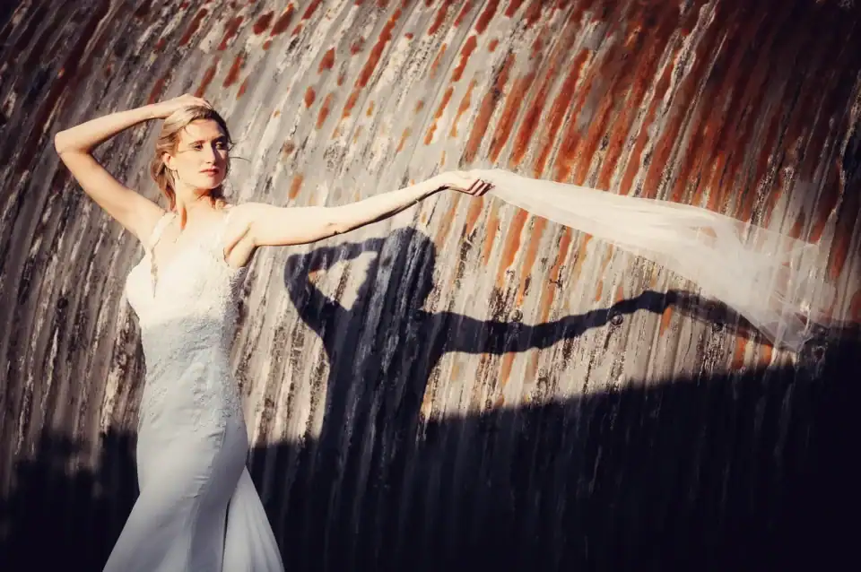 Bride waves her veil in a corrugated metal tunnel - Scott Gilbert Wedding Photography