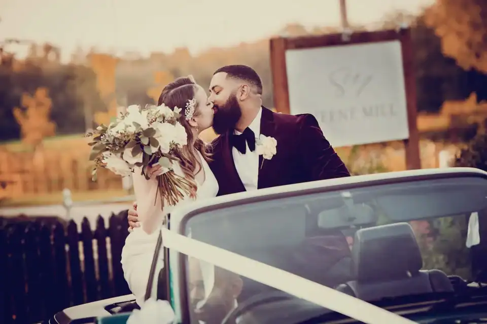 Bride and groom kiss whilst in the back of a convertible car at Sheene Mill - Scott Gilbert Wedding Photography