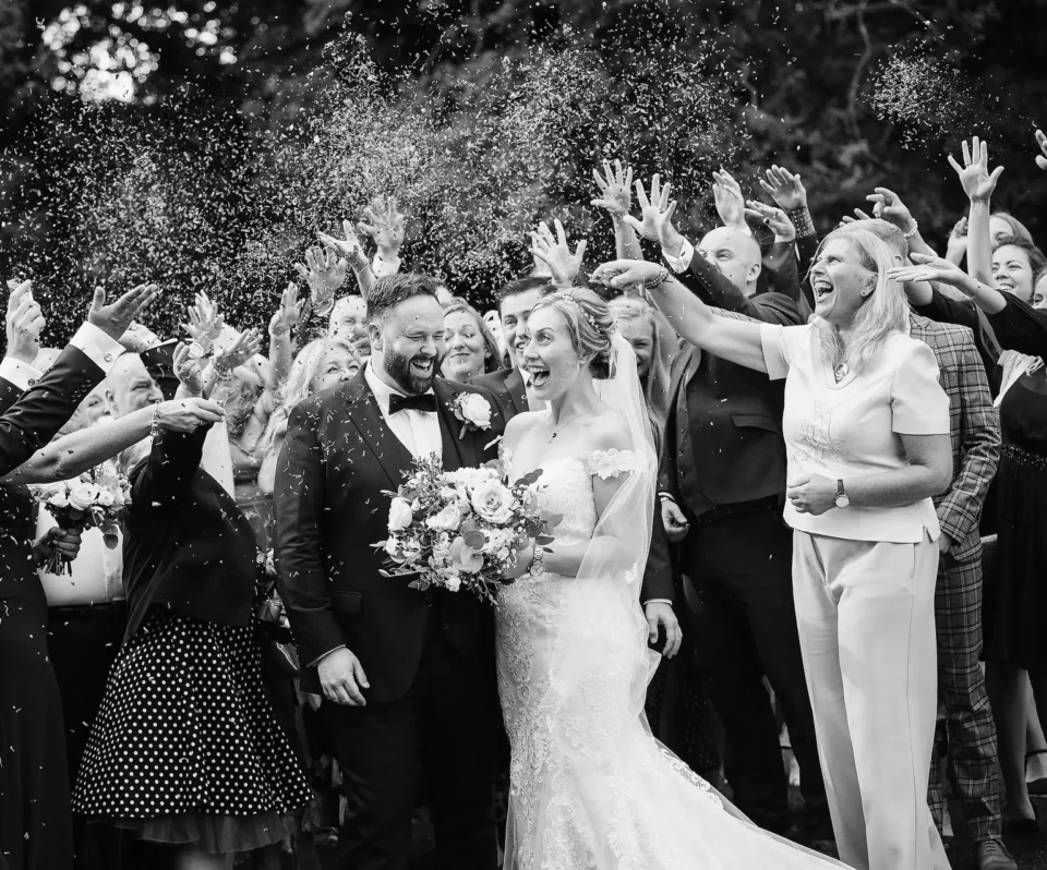 Wedding celebration with guests throwing confetti at the newlyweds.