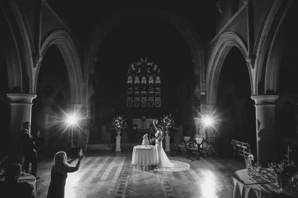 Bride and groom cut the cake in huge hall - Scott Gilbert Wedding Photography