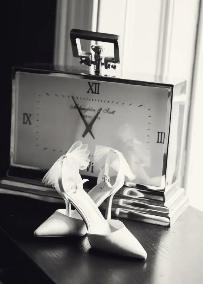 White wedding shoes in front of rectangular clock - Scott Gilbert Wedding Photography