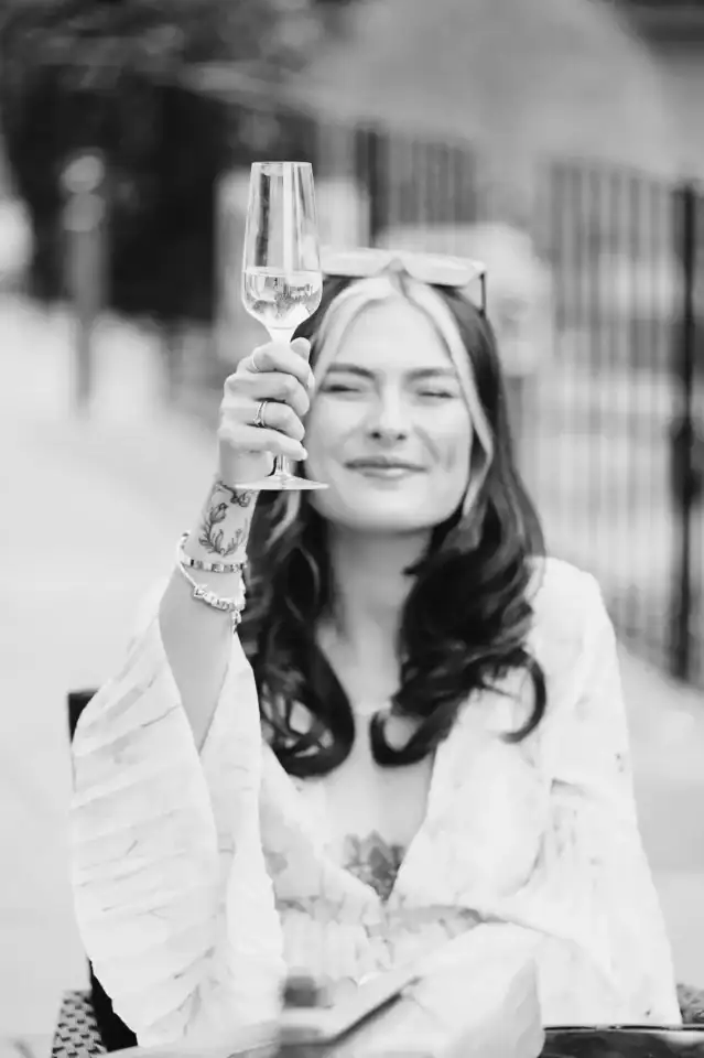 Wedding guest cheers a glass of champagne to the happy couple - Scott Gilbert Wedding Photography