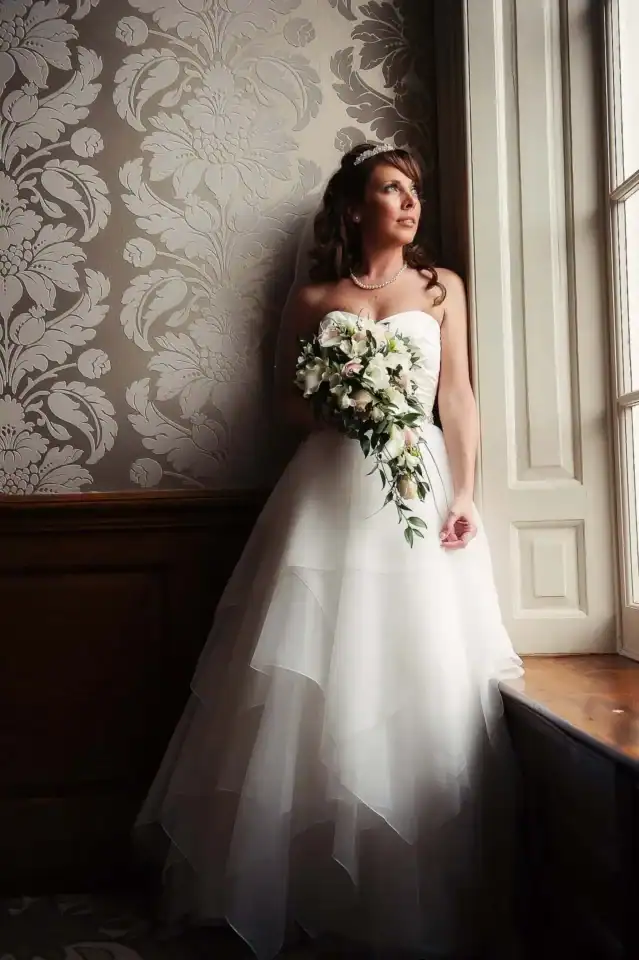 Bride staring out of window in a manor house - Scott Gilbert Wedding Photography