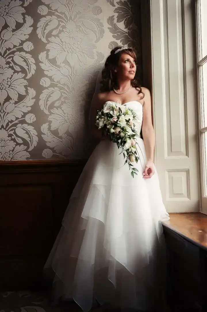 Bride staring out of window in a manor house - Scott Gilbert Wedding Photography
