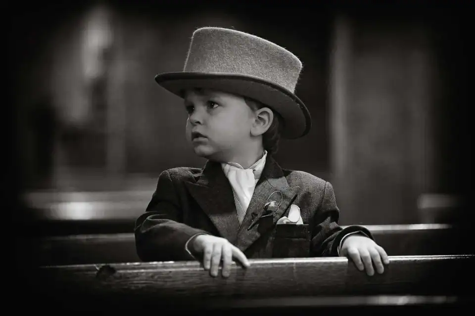 Young ring boy waits in church for his big moment wearing a top hat - Scott Gilbert Wedding Photography