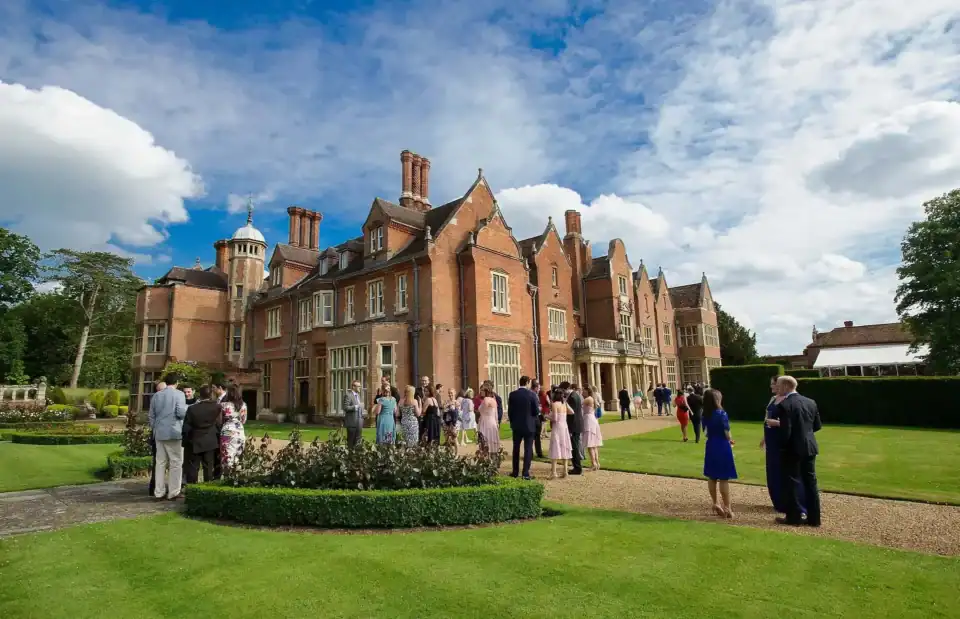 Wedding guests gather outside Longstowe Hall - Scott Gilbert Wedding Photography