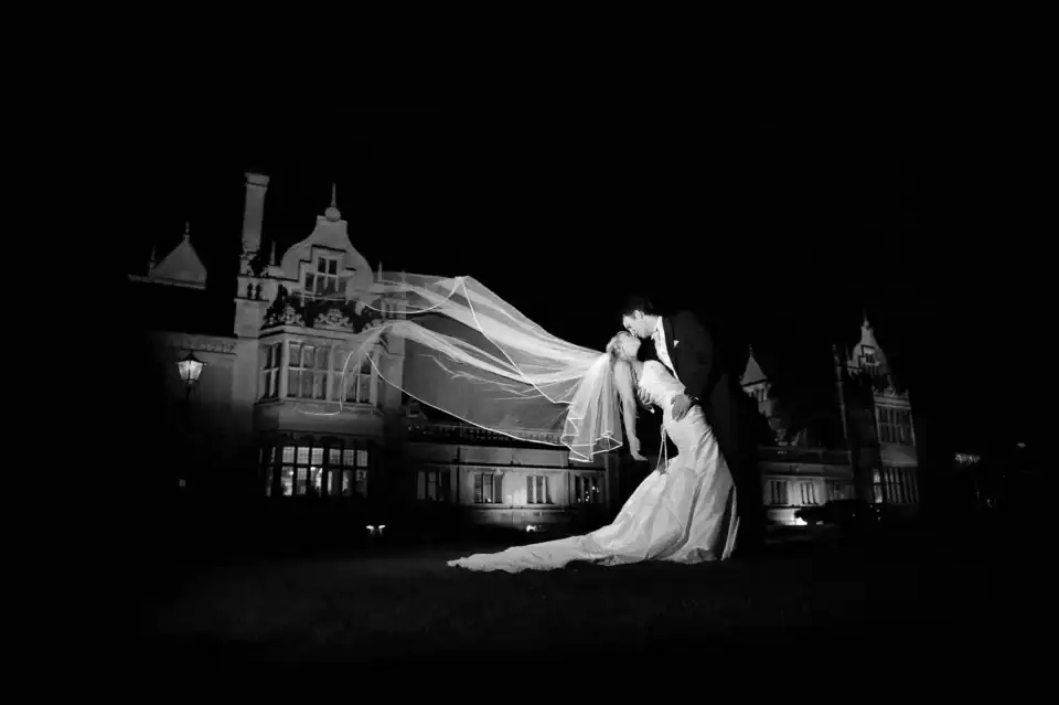 Newly weds kiss at night outside their wedding venue - Scott Gilbert Wedding Photography
