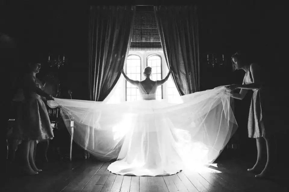 Brides dress is held out by bridesmaids as she prepares for the wedding - Scott Gilbert Wedding Photography