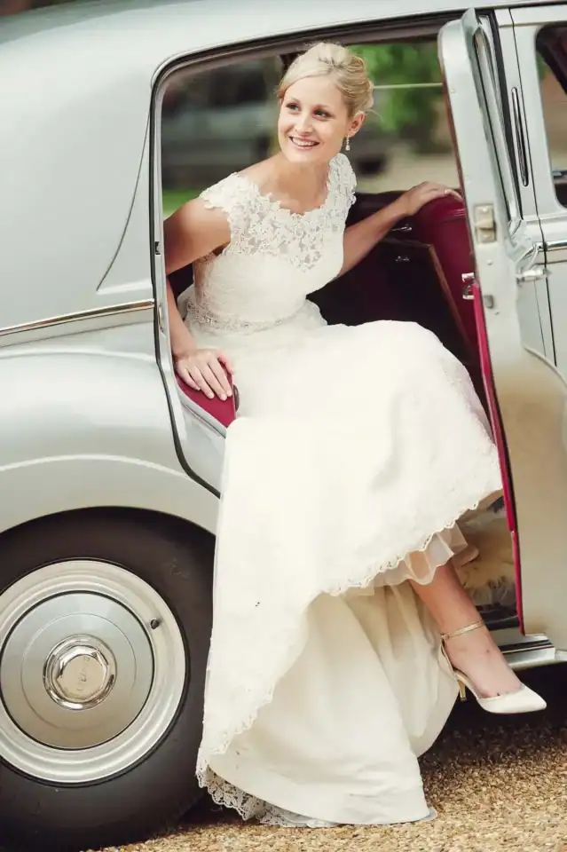 Bride exiting classic Rolls Royce Silver Cloud with red leather interior - Scott Gilbert Wedding Photography