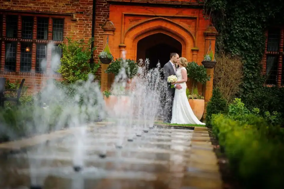 Couple kiss in front of fountains at their wedding venue - Scott Gilbert Wedding Photography