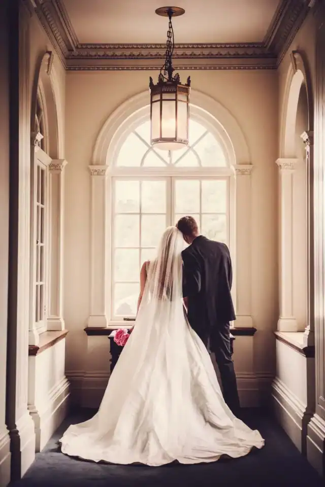 Newly weds gaze out of window from their wedding venue - Scott Gilbert Wedding Photography