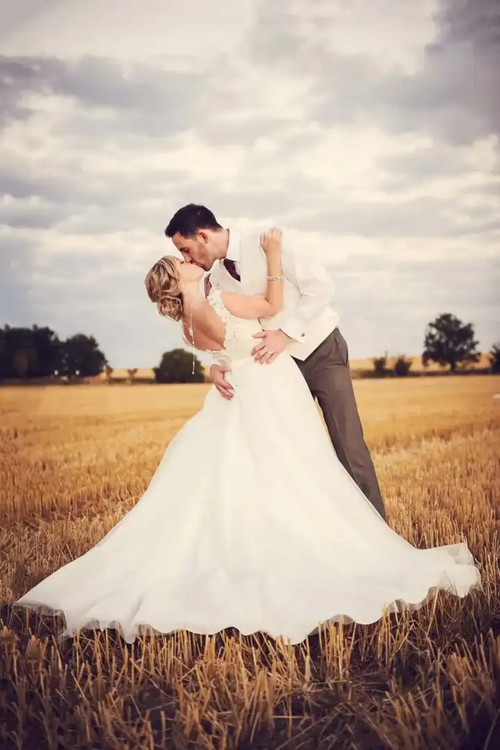 Bride and groom happy married kiss in field Cambirdgeshire - Scott Gilbert Wedding Photography