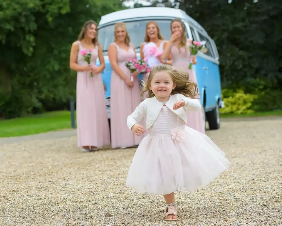 Bridesmaid running towards camera with VW campervan in the background - Scott Gilbert Wedding Photography