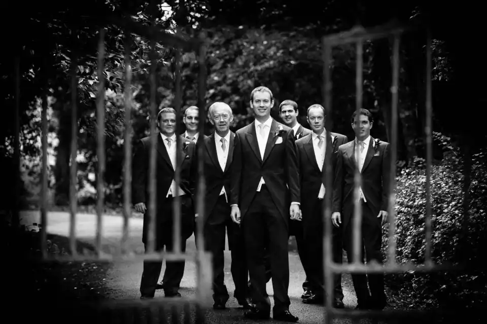 Groomsmen stand behind gate - Scott Gilbert Wedding Photography