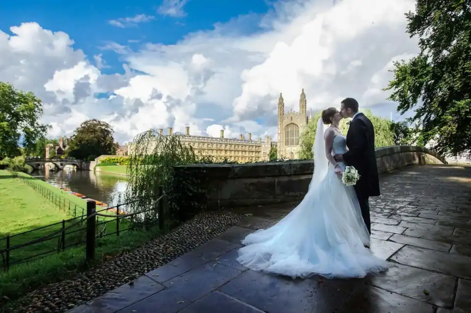 Couple kiss on famous bridge outside Kings College University Cambridge - Scott Gilbert Wedding Photography