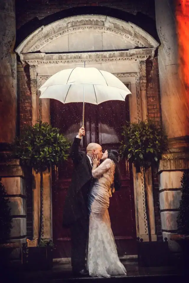Married couple holding an umbrella whilst sharing a kiss - Scott Gilbert Wedding Photography
